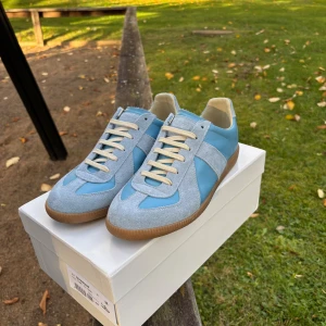 Maison Margiela gats  blå - Jag säljer dessa feta maison margiella gats i ljusblå. Skorna är gjort av läder samt mocka med på designen. Skorna har inga synliga defekter och är sparsamt använda. Skriv ifall du har några funderingar. Kan även diskutera pris.