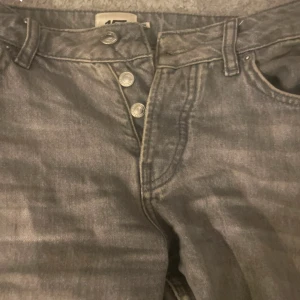 157 -  jeans med klassisk knappgylf och raka ben. Jeansen har en tidlös look med fem fickor och är tillverkade i slitstarkt denim. Perfekta för dig som gillar en avslappnad och autentisk stil.