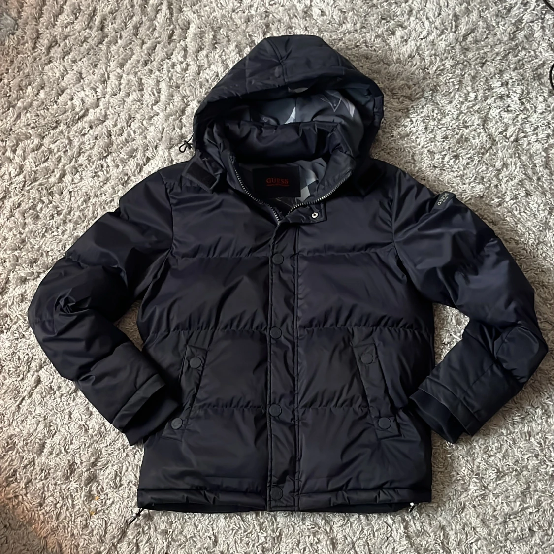 Svart pufferjacka från Guess med huva