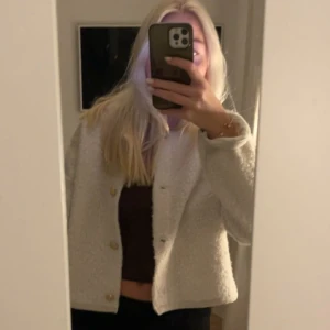Vit teddyjacka med knappar - Säljer en vit teddyjacka , men kan användas som kofta med. . Jackan är tillverkad i mjukt teddy-material som ger en mysig vibe. Perfekt för dig som vill ha en stilren och trendig look. Den är i storlek L men sitter som en M , inga defekter 🩷