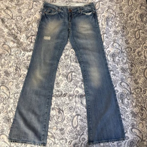 Lågmidjade utsvängda jeans  - Lågmidjade utsvängda jeans  Midjemått rakt över: 41cm Innerbenslängd: 85cm Total längd: 104cm Benvidd nedtill: 22cm