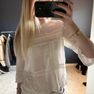 Vit blus med spets från ONLY - Säljer en söt vit blus från ONLY i storlek 34. Blusen har fina spetsdetaljer och diskret mönster i tyget, samt trekvartsärmar med lätt volang vid ärmslut. Perfekt för dig som gillar romantisk och feminin stil.