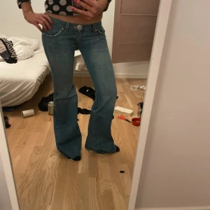 Blå bootcut jeans låg midja - Säljer ett par blå jeans med låg midja och bootcut-modell. Supersnygga men för små för mig. Inte mina bilder. Byxorna är insydda i låren💕