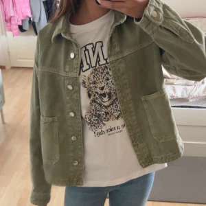 Olivgrön manchesterjacka - Snygg olivgrön jacka i manchester med raka linjer och stora fickor framtill. Jackan har knappar hela vägen och klassisk krage. Perfekt för dig som gillar en avslappnad men trendig stil.