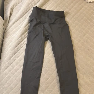 Svarta leggings från Aim'n, storlek S - Snygga svarta leggings från Aim'n med hög midja och bred ribbad linning. Tillverkade i ett stretchigt material av 92% polyamid och 8% elastan som sitter tight och bekvämt. Perfekta för träning eller chill dagar.