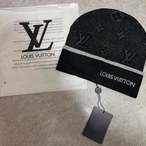 Svart mössa(gratis frakt) - Snygg svart mössa med klassiskt monogrammönster och grå rand. Märkets logga är broderad framtill. Perfekt accessoar för dig som vill ha en lyxig och trendig look i vinter.(Endast mössa)