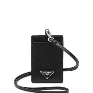 Svart plånbok med halsband - Minimalistisk svart plånbok med axelrem och ikonisk metalltriangel med logga framtill. Tillverkad i exklusivt skinn med stilren design och praktisk rem för att bära runt halsen eller över axeln. Perfekt för kort och småsaker.