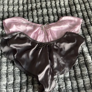 2 pyjamas shorts från Primark, rosa & grå - Två snygga satinshorts från Primark i storlek M. En är ljusrosa och den andra är grå, båda med glittrigt knytband framtill och volangkant. Perfekta för en kväll man vill känna sig lite extra fin med en touch av glamour och mjukt fallande material. ”Pyjamas shorts” 170 för båda