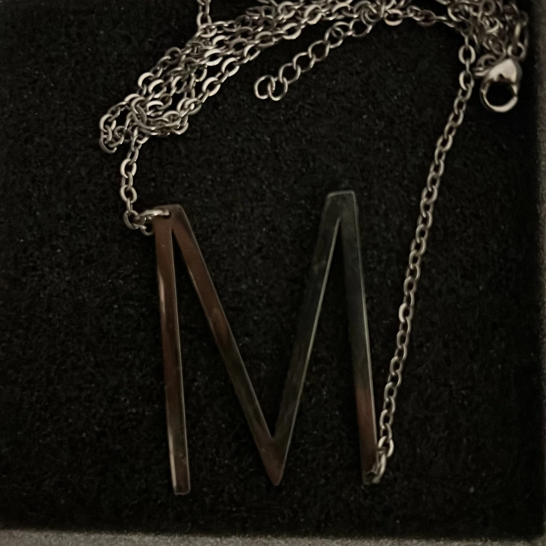 Silverfärgat halsband med bokstaven M