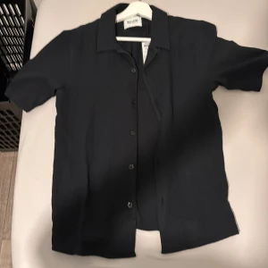 Mörkblå skjorta från Only & Sons XS - Mörkblå skjorta från Only & Sons i storlek XS. Skjortan har korta ärmar och materialet är mjukt och lätt.