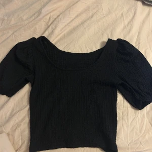 Svart puffärm blus från lager157 - Svart blus från 157 i storlek XS med puffiga korta ärmar och smockad struktur. Stretcing och bekväm🫶🏼!!!välj postnord när du beställer inte instabox!!!