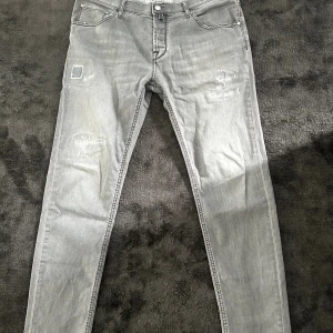 Grå jeans från Jacob Cohën, storlek 35 - Snygga grå jeans från Jacob Cohën med slitna detaljer och patch på bakfickan.