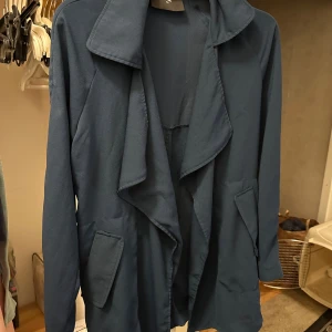 Mörkblå kofta  från BikBok XS - Snygg mörkblå kofta från BikBok två fickor framtill. Koftan  har lång ärm och är tillverkad i ett mjukt, tunt tyg som ger ett avslappnat intryck. Perfekt för dig som gillar stilrena och enkla plagg.