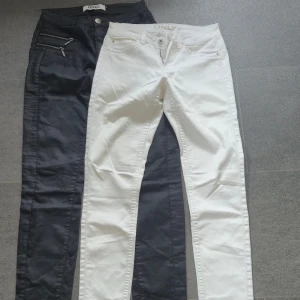 Svarta och vita skinny jeans från ONLY - Två par jeans från ONLY, ett par svarta och ett par vita. Båda har klassisk femficksdesign, skinny fit och dragkedja med knapp framtill. De svarta har extra dragkedjedetaljer vid fickorna. Perfekta för dig som gillar stilrena och tajta jeans.
