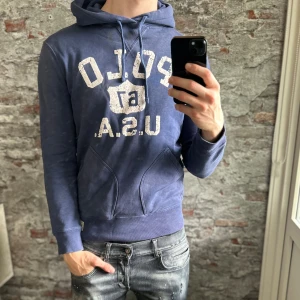 Ralph lauren hoodie -  Bra skick, inga defekter men trycket är lite slitet. Storlek 48/S passar dig som är mellan 175-185cm. Nypris ca 2500kr. Modellen är 185 cm, 79 kg. Passar bra nu till höst/vinter. Skriv för mer information!🤝