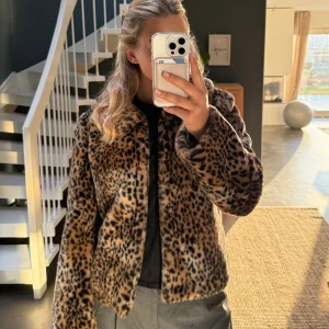 Leopardmönstrad pälsjacka - Säljer en supermjuk och fluffig pälsjacka med leopardmönster. Jackan har en klassisk krage och är i bruna och svarta toner. Perfekt för dig som vill sticka ut och hålla dig varm. Jackan är långärmad och har en schysst oversized vibe.