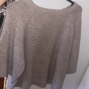 Beige stickad tröja med vid passform - Trekvartsärmad beige tröja. Använd några gånger 
