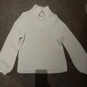 Vit stickad tröja med half zip - Mysig vit stickad tröja från nakd med hög krage och half zip-dragkedja. Tröjan har långärmad design och ribbad struktur.. Enkel och stilren modell som passar till det mesta. Köpt för 400 .Säljer för 90kr