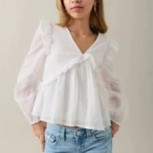 Vit volangblus med v-ringning - Säljer en söt vit blus med v-ringning och volangdetaljer, pris kan diskuteras 