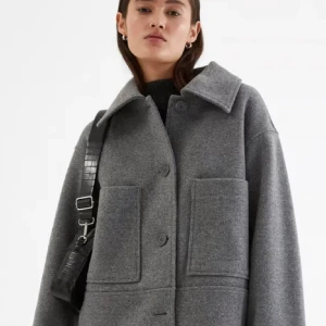 Grå kappa med fickor - Säljer en grå kappa med stora framfickor och knäppning framtill. Jackan har en boxig, oversized passform och bred krage. Pris går att diskutera