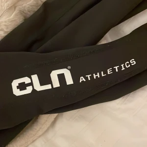 Svarta tights från CLN Athletics - XS-S.  Svarta tights från CLN Athletics med vit logga längs benet och bak på midjan. Snygg, tight passform och stretchigt material som passar perfekt till träning. Hög midja för extra komfort och stilren look.