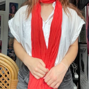 Röd sjal - Fin röd sjal men vackra detaljer i  slutet på  sjalen. Jag kan mötas upp i Uddevalla centrum, annars fraktar jag gärna. Köparen står för frakten. (Står ej för postens slarv) katt finns i hemmet. 