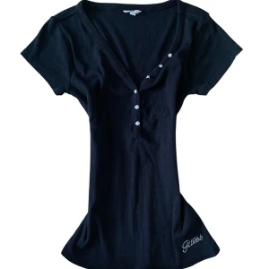 Vintage black Guess Henley top  - Vintage black Guess Henley top, size M. Don’t hesitate to ask me any questions! I’m open to receiving offers and I recommend you to create a bundle to receive extra discounts! 🌛🍒  vintage coquette 70s 80s 90s 00s 2000s thirteen Bella swan twilight vampire diaries Elena Gilbert Henley lace mesh sexy Paris Hilton mcbling pink rhinestones glimmer glamour Paul frank Hollister Abercrombie fitch autumn winter summer spring sequence Angel devil star girl grunge emo avant grande affliction VS juicy swag
