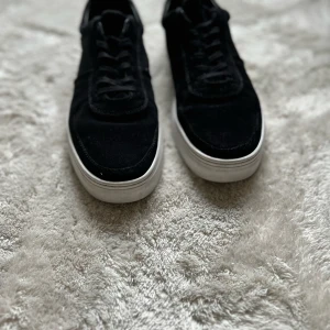 Svarta sneakers Vagabond Paul 2.0 - Snygga svarta sneakers från Vagabond  med ovandel i mocka och klassisk vit sula. Skorna har snörning och en stilren, låg profil som passar till det mesta. Perfekta för dig som gillar en clean och modern look.  Köpta för 1400 , Använda i 1 månad!