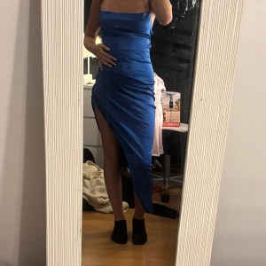 Blå lång silkes klänning med snörning  - Säljer en blå lång silkes klänning i storlek xs, använd en gång 