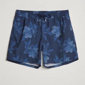Blå badshorts från Ralph Lauren Purple Label  - Säljer ett par snygga marinblå badshorts från Ralph Lauren i storlek L. Shortsen har elastisk midja med snörning och kommer med en praktisk förvaringspåse. Materialet är syntet och de har innerbyxa i mesh. Perfekta för stranden eller poolen. Nypris 3k