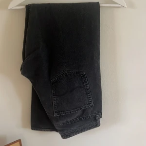 Svarta loose fit jeans Loose Chris - Svarta jeans från Jack n Jones  i modellen Loose Chris. De har en loose passform och raka ben, klassisk femficksdesign och cool tvättad look. Perfekta för dig som gillar avslappnad stil och vill ha bekväma jeans med lite extra utrymme.