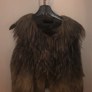Diesel väset  - Säljer en Grå  pälsväst från Diesel . Västen har en cool,  fluffigt fu öppen front. Perfekt för att ge din outfit en extra edge och värme under höst och vinter.