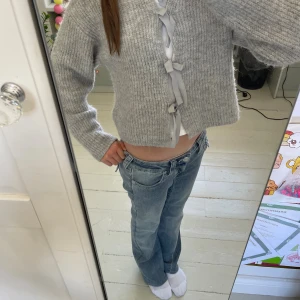 Grå stickad kofta med snörning - Superfin grå stickad kofta med breda ribbade ärmar och snygg snörning framtill. Kortare modell som är perfekt att slänga över ett linne eller t-shirt. Mjuk och mysig, passar perfekt till jeans för en chill look. Perfekt nu till hösten och vintern!!❄️🩶