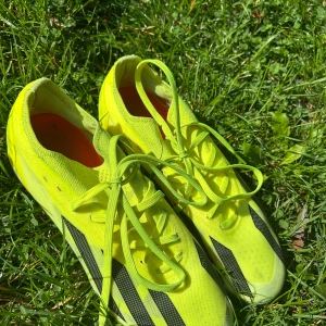 Adidas Crazyfast fotbollsskor - Säljer ett par Adidas Crazyfast fotbollsskor i neon-gult med svarta detaljer och röda dobbar. Skorna har snörning och är tillverkade i lätt syntetmaterial för maxad speed på planen. Perfekta för dig som vill sticka ut och dominera matchen. Den här modellen är min favorit modell!😻💕⚽️👟