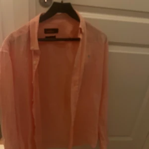 Ljusrosa skjorta från Morris - Säljer en ljusrosa skjorta från Morris. Skjortan har klassisk krage, knäppning framtill och långa ärmar.