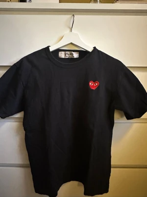 Svart Comme des Garçons PLAY t-shirt - Svart t-shirt från Comme des Garçons PLAY som är köpt på NK. Bra skick. Pris kan diskuteras!