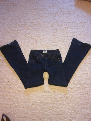 Lågmidjade bootcut jeans - Mörkblå jeans från Urban Outfitters🤩 lågmidjade, storlek 24/32 men passar även större eftersom de är stretchiga, fint skick☺️