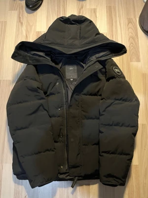 Canada Goose Macmillan - Säljer denna Canada Goose vinterjackan, modellen är Macmillan i färgen svart med svart logga vid armen. Jackan är ej min stil så därför den säljs. Perfekt nu inför vintern❄️ Jackan har inga fläckar och de ser ut som det på grund av min kamera. Jackan är i fint skick och har inga skador eller så, köpsbevis, prislapp och påse medkommer. Om du är intresserad eller har frågor så är det bara att höra av dig🤝