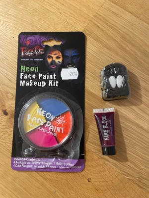 Neon ansiktsfärg och fejkblod kit - Säljer ett Face On Neon Face Paint Makeup Kit med fyra neonfärger (gul, blå, rosa, orange) och en sminkpensel. Medföljer även ett litet rör fejkblod och ett par vampyrtänder i plast – perfekt för halloween eller maskerad. Fejkblodet är endast använt väldigt väldigt lite, resten är oöppnat