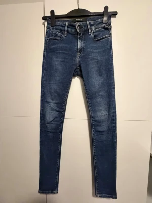 Replay skinny jeans blå denim Luz Hyperflex - Säljer ett par snygga blå skinny jeans från Replay med klassisk femficksmodell och gul kontrastsöm. Jeansen har en mörk tvätt med lätt slitningar och är tillverkade i stretchig denim. Modell Luz Hyperflex. 