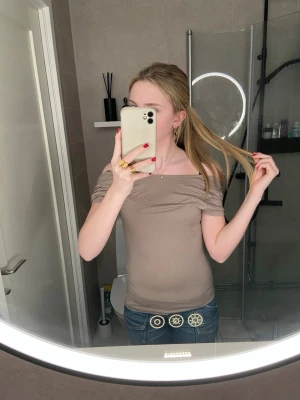 Beige topp med öppen rygg - Säljer en beige topp i mjukt bomullsmaterial. Toppen har korta ärmar och en snygg öppen rygg som ger en extra touch. Den är figurnära och passar perfekt till jeans eller shorts. Enkel och stilren design som funkar året runt.