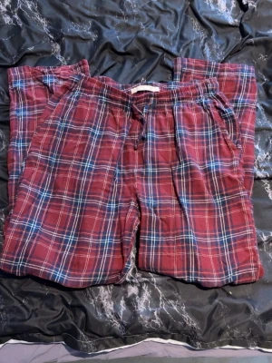 Röd-rutiga mjukisbyxor från 157 - Säljer ett par sköna mjukisbyxor från 157 i storlek S. Byxorna är röd-rutiga med inslag av blått och vitt, har elastisk midja med snörning och sidofickor. Perfekta för chill hemma eller häng med kompisar.