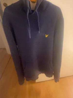 En mörkblå hoddie med snören - En mörkblå hoddie från lyle Scott i storlek xs. Tröjan är använt ett fåtal gånger 