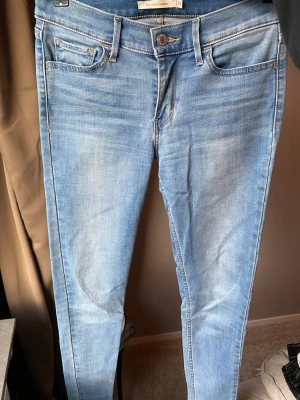 Levi's 710 Super Skinny ljusblå jeans - Ljusblå Levi's 710 Super Skinny jeans med klassisk femficksdesign och skinny passform. Jeansen har hög midja, snygga slitningar och Levi's patch bak. Tillverkade i stretchigt denim för extra komfort och rörelsefrihet. Snygga till stövlar. 