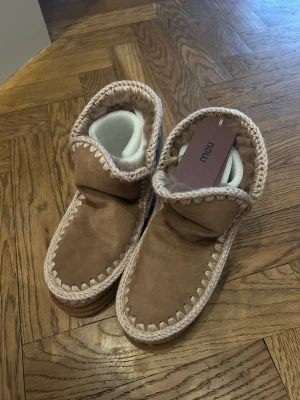 Beigea Mou boots  - Säljer ett par beige boots från Mou i mjuk mocka med grov stickad kant runt öppningen och längs sulan💕Modellen eskimo 18 i färgen pink brown, nypris 2500 kr från Mous hemsida 