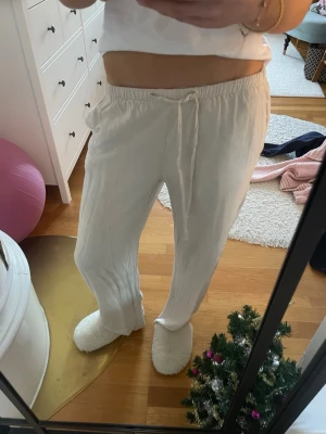 Beiga linnebyxor med snörning - Säljer ett par beiga linnebyxor med avslappnad passform och snörning i midjan. Byxorna har rak siluett och är gjorda i ett lätt och luftigt linnematerial, perfekta för chill dagar. Så snygga och som nya!