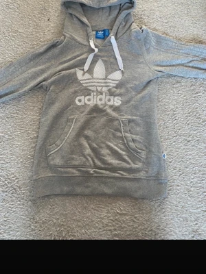 Grå Adidas hoodie - Både jätte fin och skön adidas hoodie som passar till tjejer och killar. Använd ett par gånger och säljer då den inte längre kommer till användning💞☺️