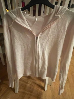 Ljusrosa hoodie med dragkedja Gina Tricot - Mysig ljusrosa hoodie från Gina Tricot i storlek 146/152. Tröjan har dragkedja framtill, huva och långa ärmar. Tillverkad i mjukt material som känns skönt mot huden. Perfekt för chill dagar eller när du vill ha en enkel och snygg look.