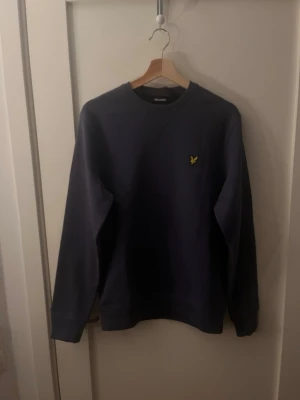 Marinblå sweatshirt från Lyle & Scott - Snygg blå sweatshirt från Lyle & Scott, tröjan är oanvänd med prislappen kvar! Nypris på tröjan ligger på 849kr men jag säljer min för 399kr! Hör av dig om du har några frågor om tröjan.