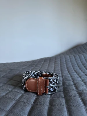 Svart vitt grått flätat bälte - Tja den är helt nytt längd 105cm och bred 3,5cm från BÄLTGALLERIAN